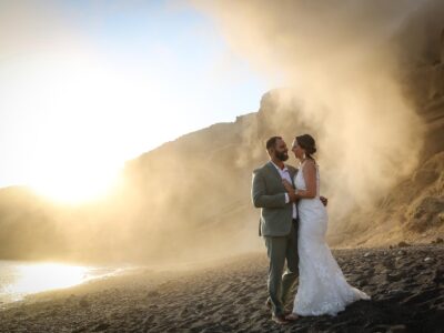 DIY ELOPEMENT, bride and groom ατ landslide moment while exchanging their vows at a Santorini beachside