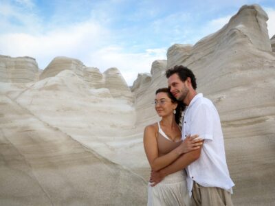 portrait of a couple in love at Sarakiniko beach with the white curved magnificent stones in cyclades complex island, Greece